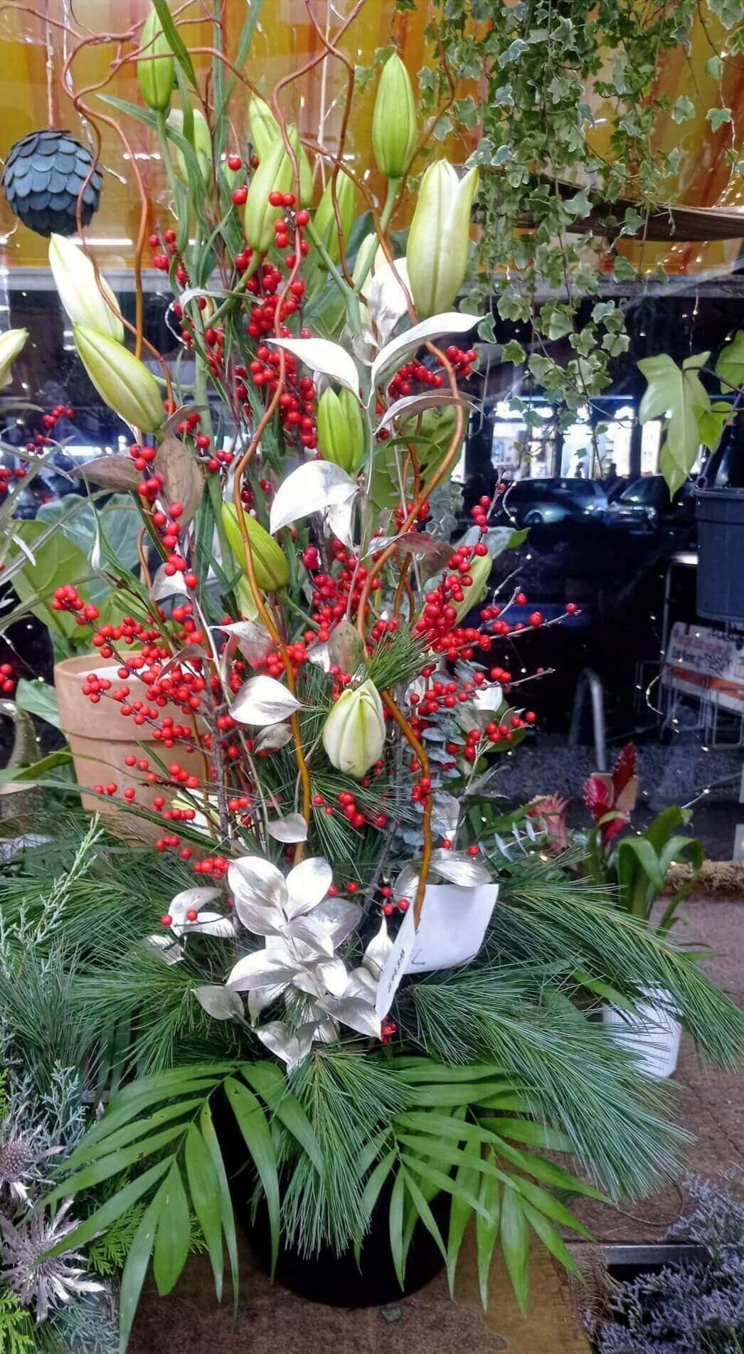 ilex-stechpalme-kompo Weihnachtsgesteck mit Lilien, Stechpalmen, Kiefernnadeln, Tannen und grünen Elementen